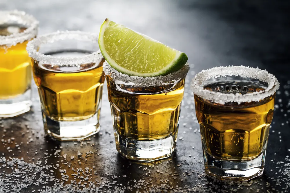 tasty-bebida-de-alcohol-tequila-cocktail-con-lima-y-sal-sobre-fondo-oscuro-vibrante-de-cerca-horizontal